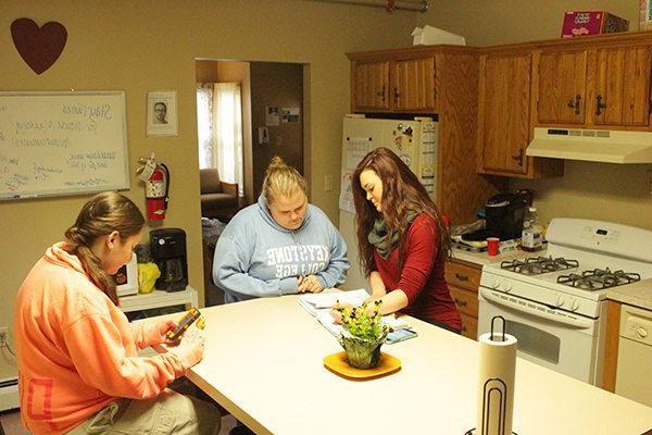 Three Keystone College students study around kitchen counter